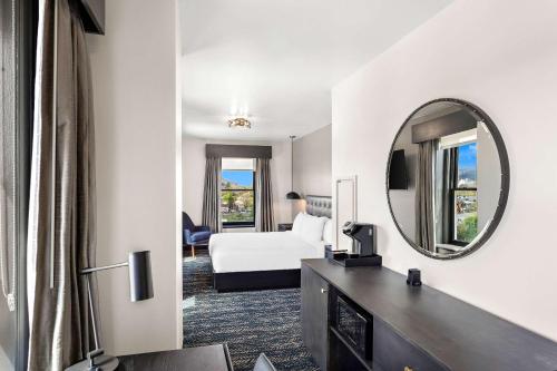 a hotel room with a bed and a mirror at Tygart Hotel, an Ascend Collection Hotel in Elkins