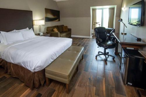 a hotel room with a bed and a desk and a chair at Chateau Cartier Hotel & Resort, an Ascend Collection Resort in Gatineau