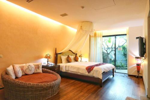 a bedroom with a bed and a wicker chair at The Mudan in Checheng