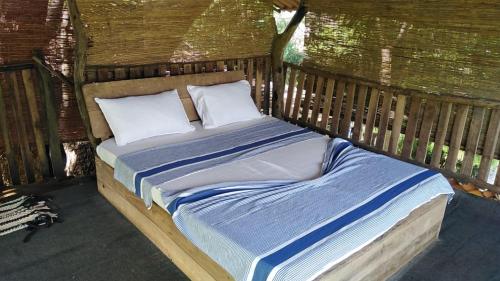 a bed with two pillows in a wooden structure at Eco Lodge Safari in Karuwalagaswewa
