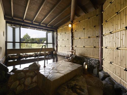a room with a bench in a room with a window at Hakuba Alps Hotel in Otari
