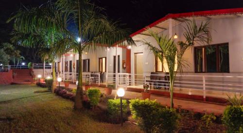a house with palm trees in front of it at night at Ekantam Aspen By Yatri India Hospitality in Rishīkesh