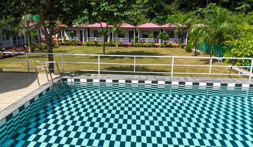 a swimming pool with a blue and white checkered floor at Ekantam Aspen By Yatri India Hospitality in Rishīkesh