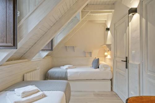 two beds in a room with an attic at Luderna - Casa con jardín Bedrera in Salardú