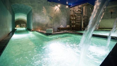 a indoor swimming pool with a water fountain at Hospes Palacio del Bailio, a Member of Design Hotels in Córdoba