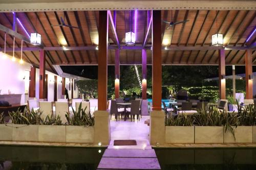 a restaurant with tables and chairs and purple lighting at Swanee Grand in Negombo