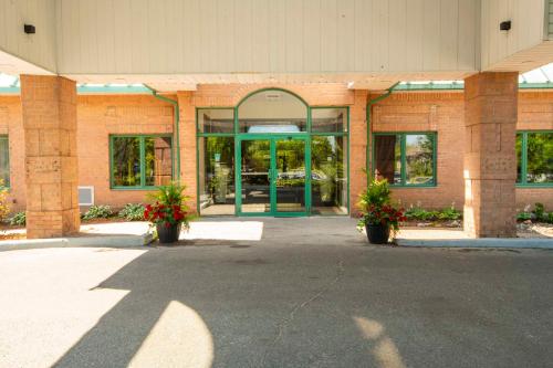 a large brick building with glass doors and flowers at Chateau Cartier Hotel & Resort, an Ascend Collection Resort in Gatineau
