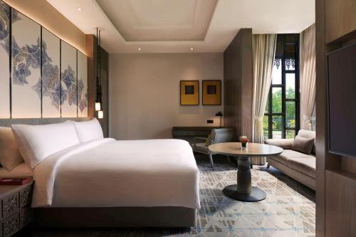 a bedroom with a bed and a living room at DoubleTree by Hilton Putrajaya Lakeside in Putrajaya