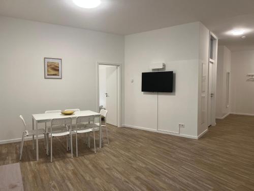 a white room with a table and a tv on a wall at T&K Apartments- 2 Room Apartment - Heart of Solingen - Private parking in Solingen