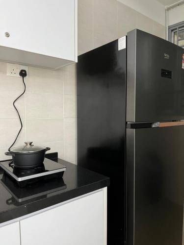 a kitchen with a black refrigerator and a bowl on a counter at Boho Bliss Escape, near Sunway Pyramid, Subang Jaya in Subang Jaya