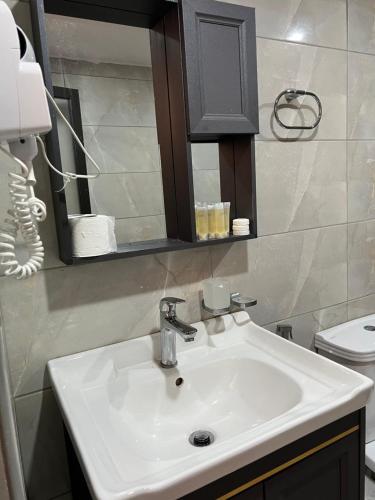 a bathroom with a white sink and a mirror at ARIANA lUXURY BUBBLE CAMB in Wadi Rum