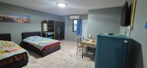 a bedroom with two beds and a tv in it at อารมย์ดี อพาทเม้นท์ ขอนแก่น in Ban Nong Waeng