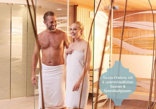 a man and a woman standing in a mirror at Hotel Stoiser in Loipersdorf bei Fürstenfeld