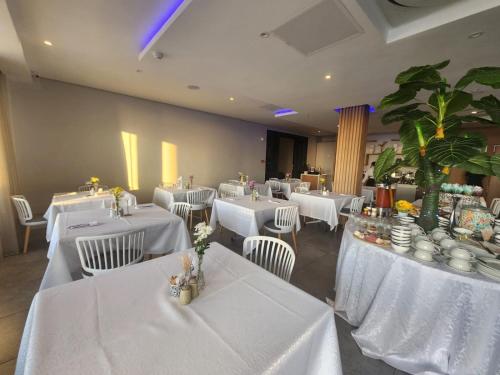 a restaurant with white tables and chairs with white tablecloths at 12 Oceans Hotel and Conference Centre in Kingsburgh