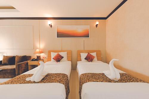 a hotel room with two beds and a couch at AU Place Hotel in Loei