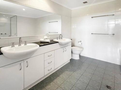 bagno bianco con 2 lavandini e servizi igienici di Unit 24 - Avoca Palms Resort ad Avoca Beach