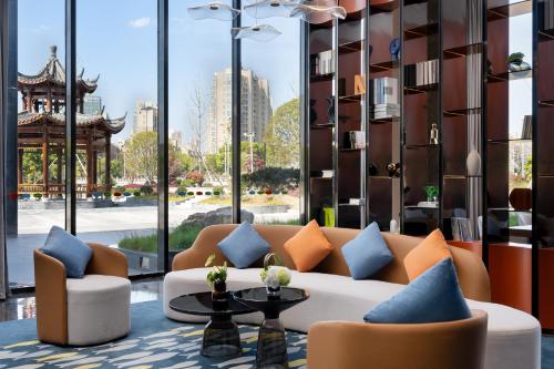 a living room with a couch and a large window at Hilton Garden Inn Jiujiang Changhong Avenue in Jiujiang