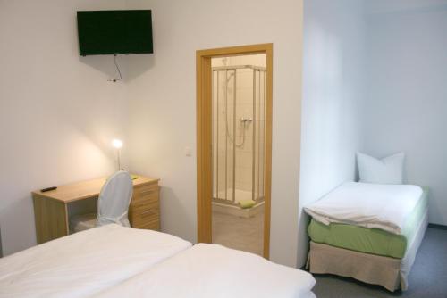 1 dormitorio con 1 cama y escritorio con silla en Lindencafe Luckenwalde, en Luckenwalde