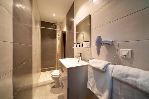 a bathroom with a sink and a toilet at Hôtel du Parc, Restaurant, Spa & Wellness in Niederbronn-les-Bains