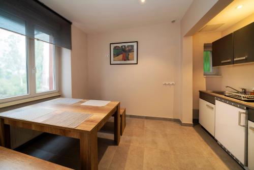 a kitchen with a wooden table and a window at Hôtel du Parc, Restaurant, Spa & Wellness in Niederbronn-les-Bains
