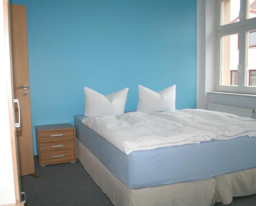 um quarto azul com uma cama com uma parede azul em Lindencafe Luckenwalde em Luckenwalde