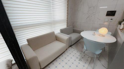 a small room with a couch and a table at Majestic Seoul Stay Central in Seoul