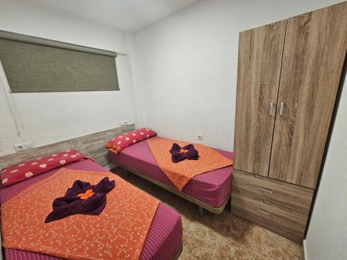 a room with two beds and a dresser in it at MobyDick 5 in Benidorm