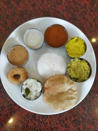 a plate of different types of food on a table at Ramraj Resort in Kanyakumari