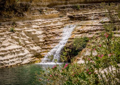 a waterfall on the side of a rocky cliff at Bellavista apartment Letojanni in Letojanni