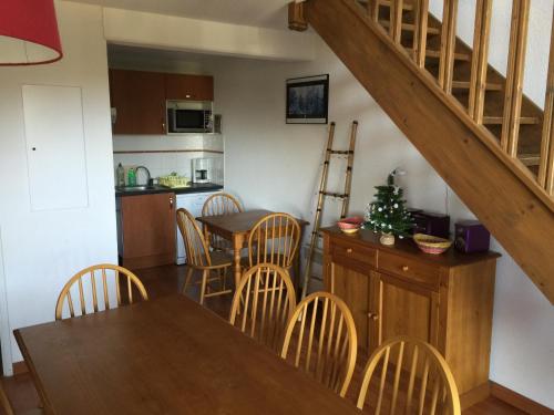 une cuisine et une salle à manger avec une table et des chaises dans l'établissement Appartement bonascre, à Ax-les-Thermes