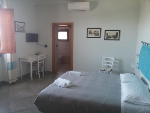 a bedroom with a bed and a table and a desk at B&B Fiori in Bonorva