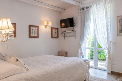 a white bedroom with a bed and a window at Villa Valentina in Levanto