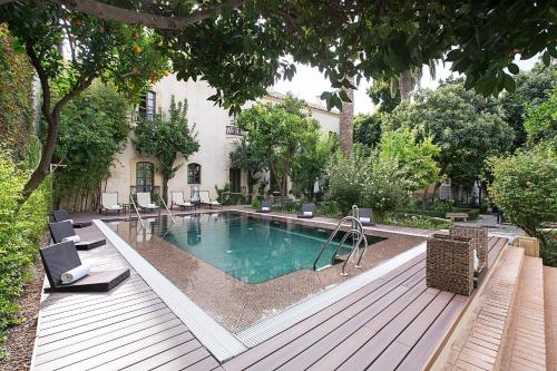a swimming pool on a deck next to a house at Hospes Palacio del Bailio, a Member of Design Hotels in Córdoba