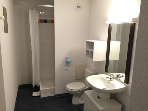 een witte badkamer met een toilet en een wastafel bij Appartement bonascre in Ax-les-Thermes