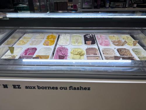 a display case with many different types of ice cream at Logement de Ville 4 chambres proche de Lille in Tourcoing