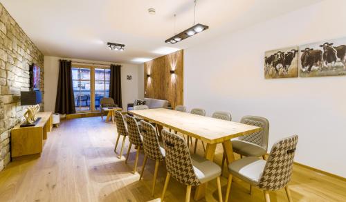 a dining room with a wooden table and chairs at Bolodges Apartments by Alpin Rentals in Saalbach Hinterglemm