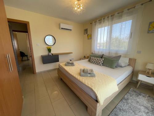 a bedroom with a large bed and a window at Nissi Beach beautiful apartment in Ayia Napa
