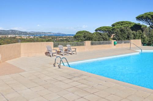 - une piscine avec 2 chaises à côté de la piscine dans l'établissement Maison Font Mourrier - Maison piscine partagée, à Cogolin