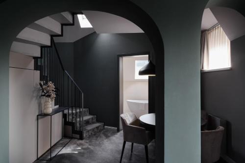 キッツビュールにあるERIKA Boutiquehotel Kitzbühelの階段、テーブル、椅子が備わる客室です。