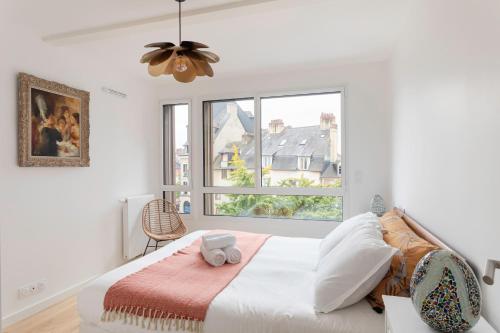 une chambre blanche avec un lit et une fenêtre dans l'établissement L'Orée Des Lices - Appt de standing à Rennes, à Rennes