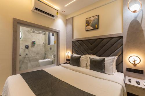 a bedroom with a large bed and a shower at Hotel Windsor Castle in Mumbai