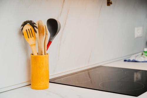 a wooden holder with knives and spatulas on a counter at Home Sofia Room 1-By EasyLife Swiss in Lugano