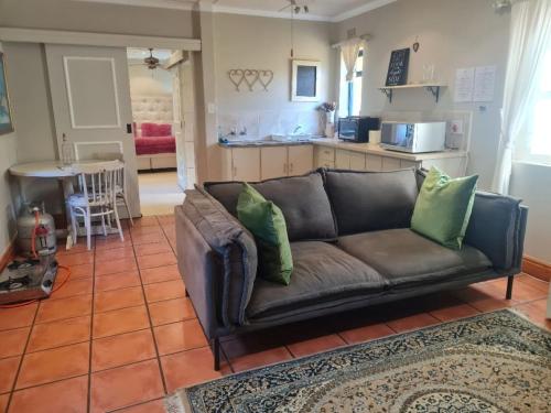 a living room with a brown couch and a kitchen at Villa Tarentaal in Tulbagh