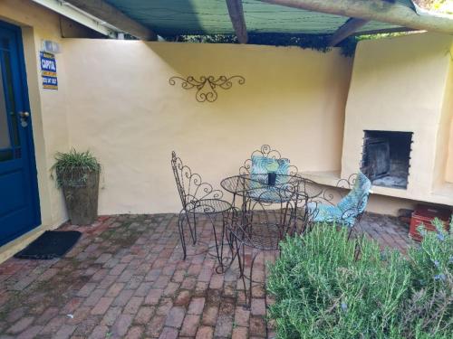 a patio with a table and chairs and a fireplace at Villa Tarentaal in Tulbagh
