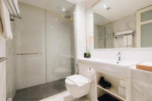 a bathroom with a shower and a toilet and a sink at Hotel NuVe Heritage in Singapore