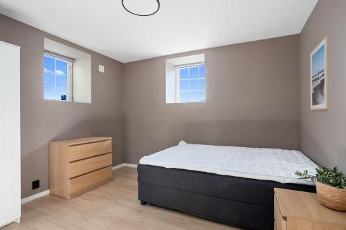a bedroom with a large bed and two windows at 6 sov l Perfekt for StayCATION in Drammen