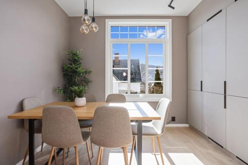 a dining room with a table and chairs and a window at 6 sov l Perfekt for StayCATION in Drammen