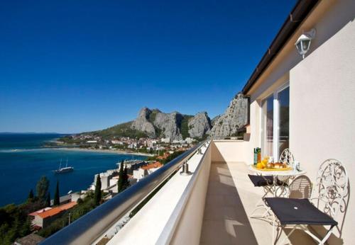 a balcony with a view of the water and mountains at House Miho in Omiš