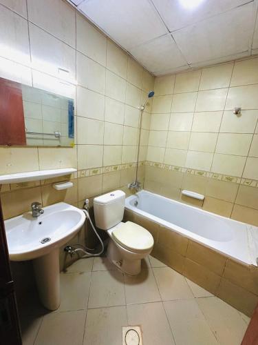 a bathroom with a toilet and a sink and a tub at Super stylish in Ajman 