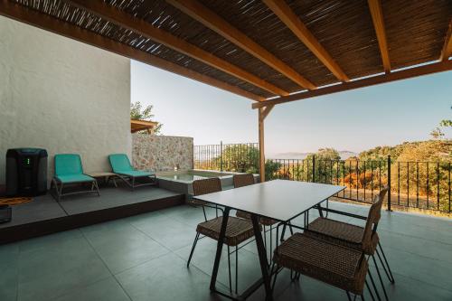 a table and chairs on a patio with a view at Villa Rosa - Luxury Villas with Panoramic Views in Lagoúdi Zía